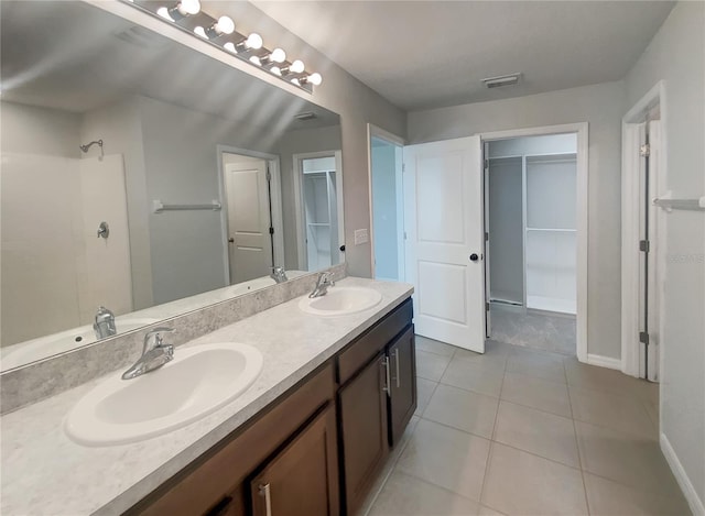 bathroom with tile patterned floors, double vanity, and a sink