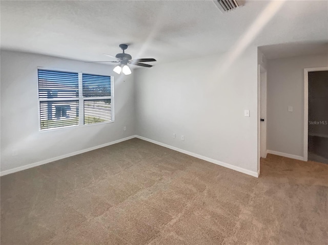 unfurnished room featuring visible vents, baseboards, ceiling fan, and carpet flooring