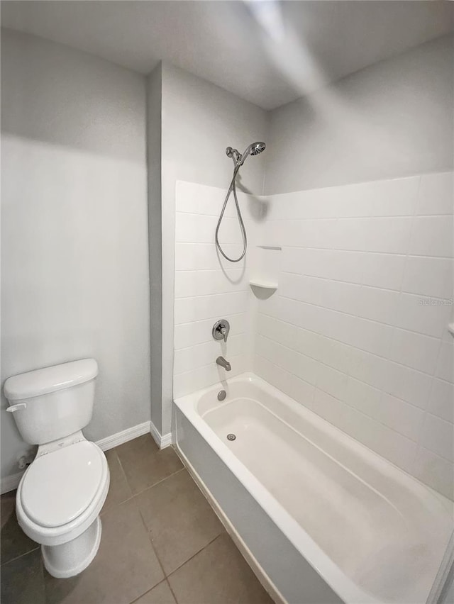 full bathroom with tile patterned flooring, toilet,  shower combination, and baseboards