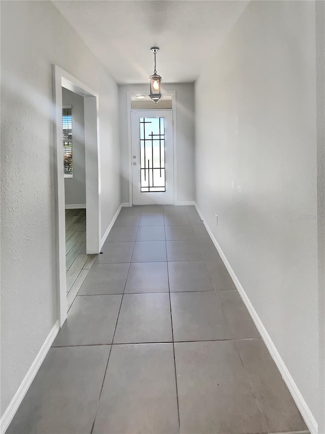 entryway with baseboards and tile patterned flooring