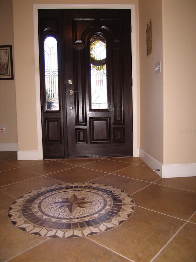 entryway with tile patterned floors and baseboards