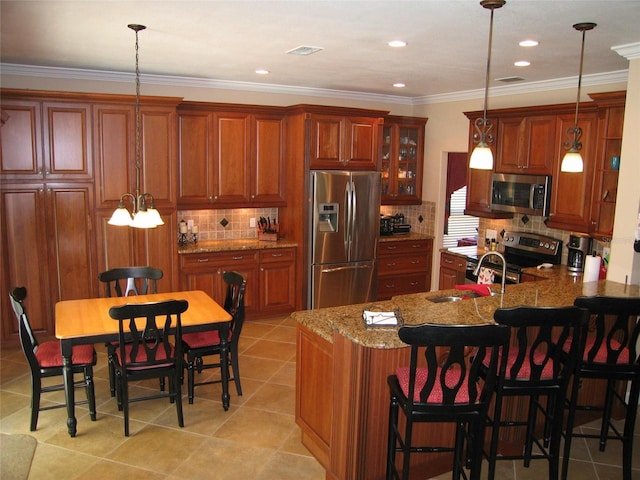 kitchen with hanging light fixtures, crown molding, light tile patterned floors, and stainless steel appliances