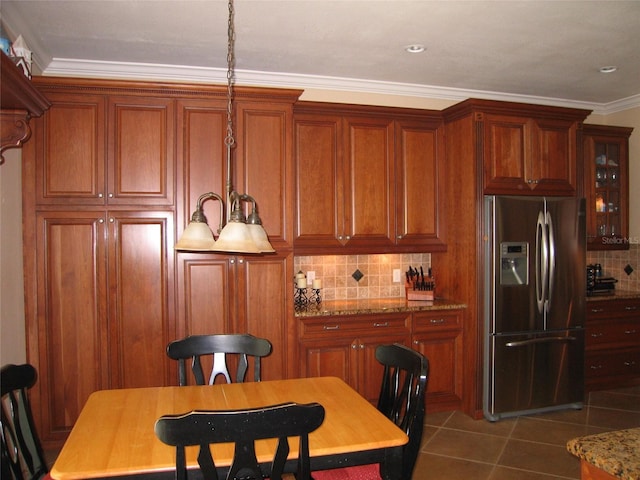 kitchen featuring brown cabinetry, ornamental molding, tile patterned flooring, decorative backsplash, and stainless steel refrigerator with ice dispenser