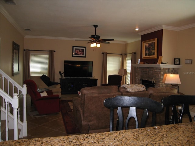 living area with visible vents, a fireplace, tile patterned flooring, stairs, and crown molding