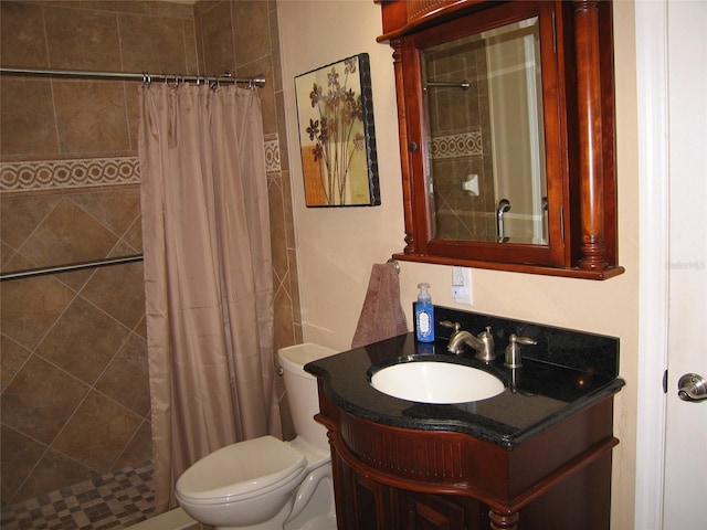 bathroom with vanity, toilet, and tiled shower