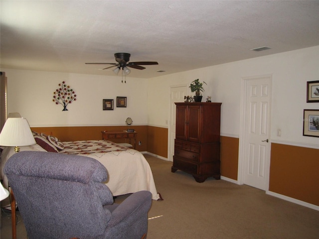 carpeted bedroom featuring a ceiling fan, visible vents, and baseboards