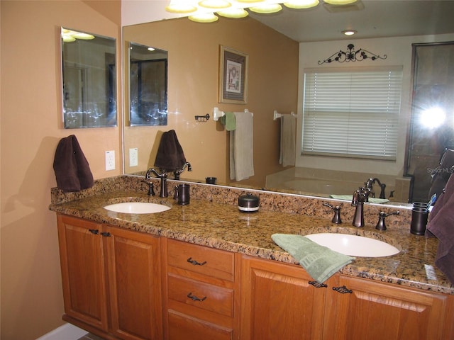 bathroom with a sink, a garden tub, and double vanity