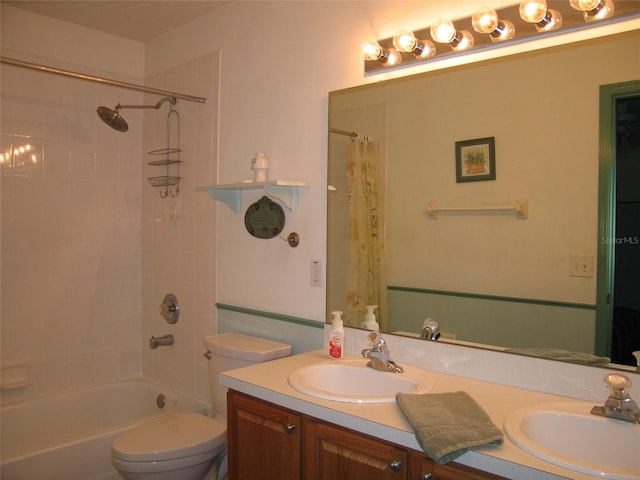 bathroom featuring double vanity, toilet, and a sink