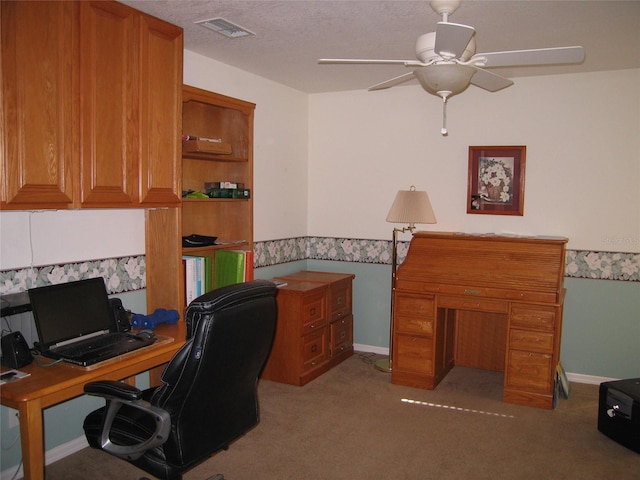 office space with baseboards, visible vents, ceiling fan, a textured ceiling, and light colored carpet