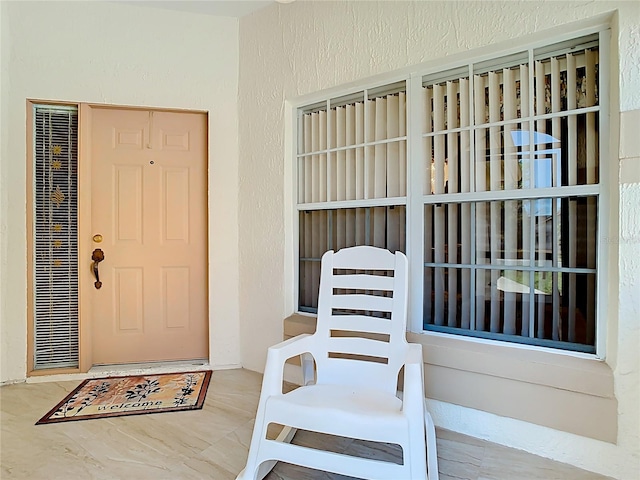 doorway to property featuring stucco siding