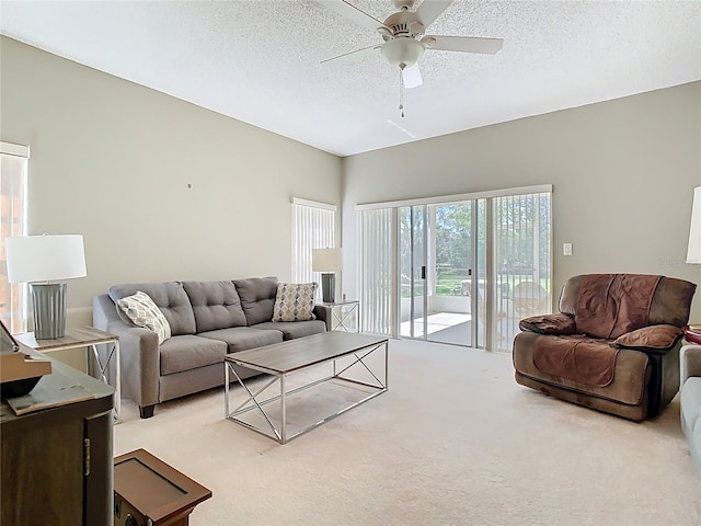 living area with carpet flooring, a ceiling fan, and a textured ceiling