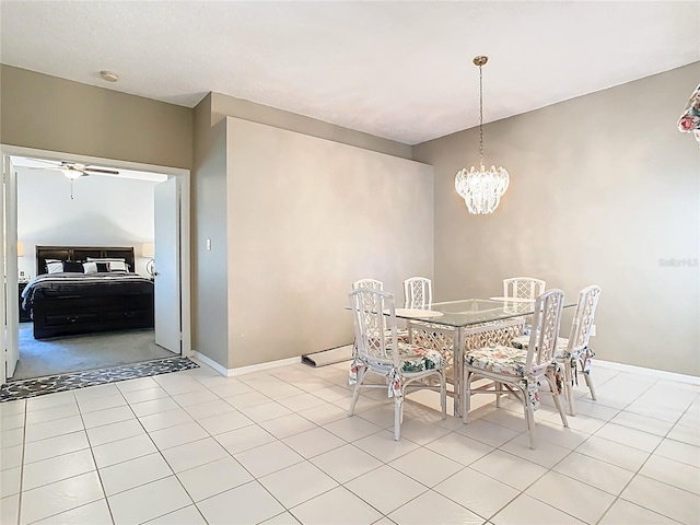 dining space with light tile patterned floors, ceiling fan with notable chandelier, and baseboards