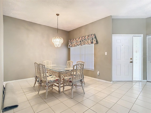 dining area featuring light tile patterned floors, a notable chandelier, and baseboards