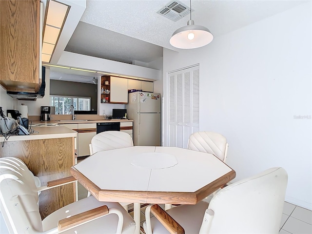 dining area with visible vents, a textured ceiling, and light tile patterned flooring