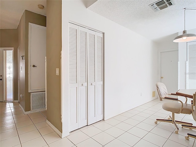 unfurnished dining area featuring light tile patterned floors, visible vents, and a textured ceiling