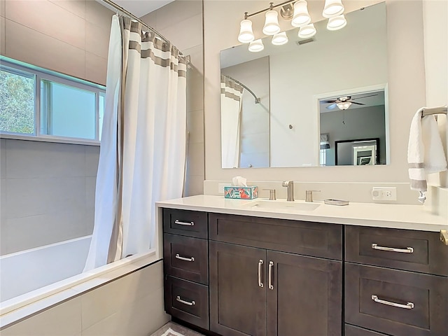 bathroom featuring visible vents, vanity, tiled shower / bath, and a ceiling fan