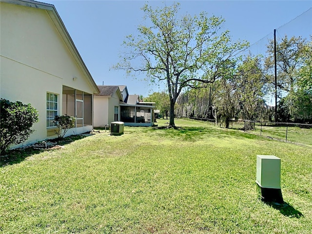 view of yard with fence and a sunroom