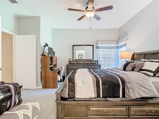 carpeted bedroom featuring visible vents, a textured ceiling, and a ceiling fan