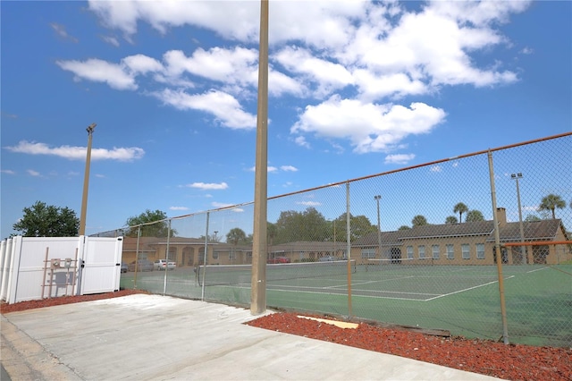 view of tennis court featuring fence