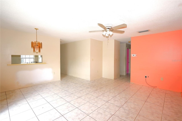 spare room featuring ceiling fan with notable chandelier and visible vents