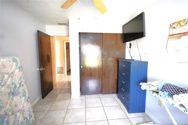 bedroom featuring ceiling fan, light tile patterned flooring, visible vents, and a textured ceiling