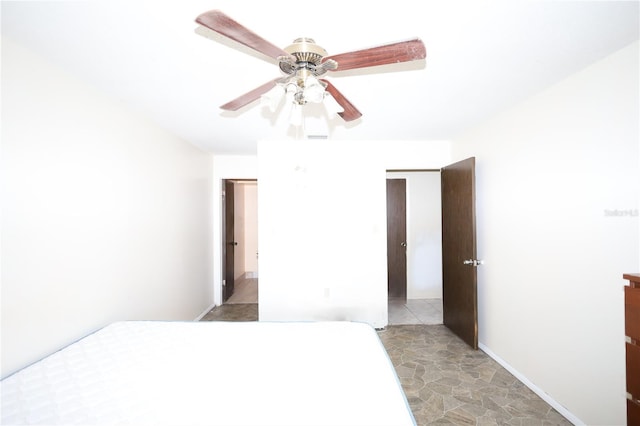 bedroom featuring stone finish floor and a ceiling fan