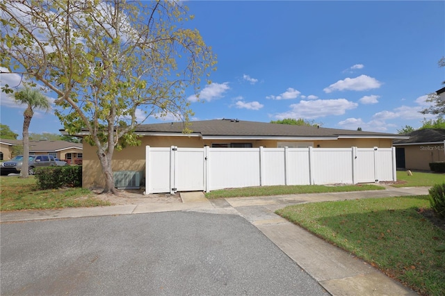 exterior space with stucco siding, fence, and a gate