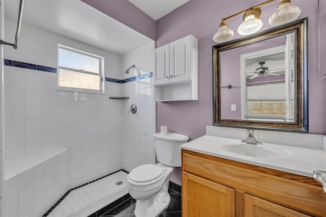 full bathroom featuring toilet, tiled shower, vanity, and a ceiling fan