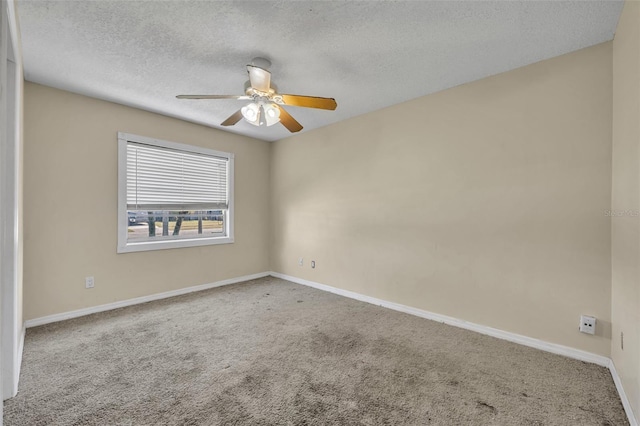 carpeted empty room with a textured ceiling, baseboards, and ceiling fan