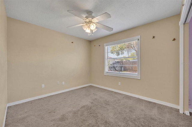 spare room with a ceiling fan, baseboards, carpet floors, and a textured ceiling