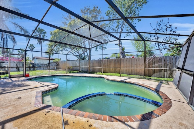 view of swimming pool featuring glass enclosure, a patio, a fenced backyard, and a pool with connected hot tub