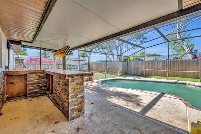 view of swimming pool featuring glass enclosure, a patio area, a fenced backyard, and outdoor dry bar