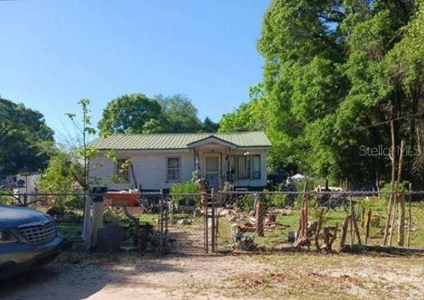 view of front of property featuring a fenced front yard and metal roof