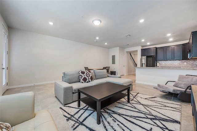 living room featuring electric panel, baseboards, stairs, and recessed lighting