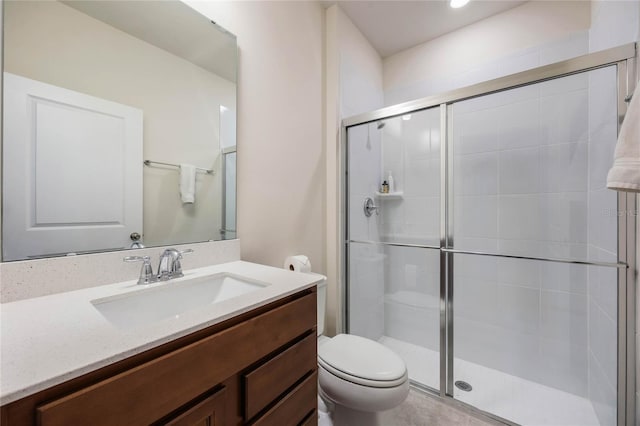 full bathroom featuring vanity, a shower stall, and toilet