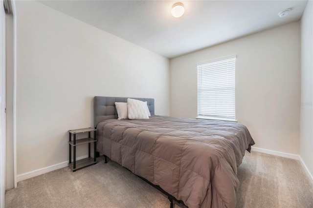 bedroom featuring light colored carpet and baseboards