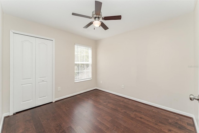 unfurnished bedroom featuring dark wood finished floors, baseboards, a closet, and ceiling fan