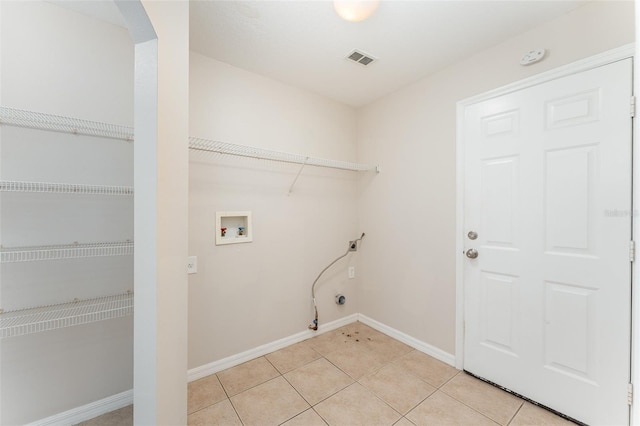 washroom with visible vents, light tile patterned floors, baseboards, hookup for a washing machine, and laundry area