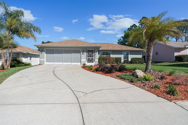 ranch-style house with stucco siding, driveway, an attached garage, and a front yard