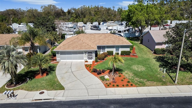 view of front of property with a residential view, driveway, an attached garage, and a front yard