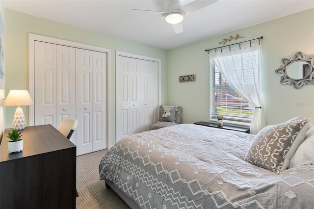 carpeted bedroom featuring two closets and a ceiling fan