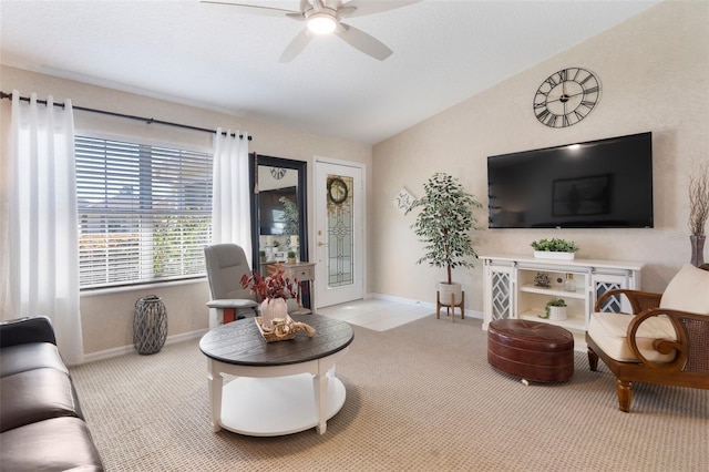 carpeted living area with ceiling fan, baseboards, and lofted ceiling