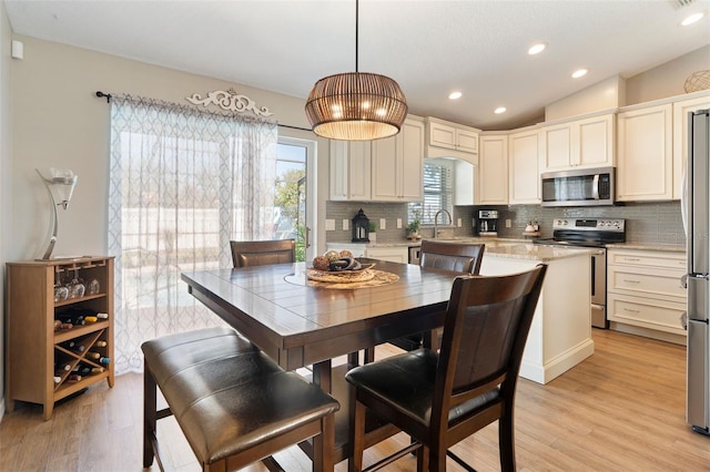 dining area featuring recessed lighting, lofted ceiling, and light wood finished floors