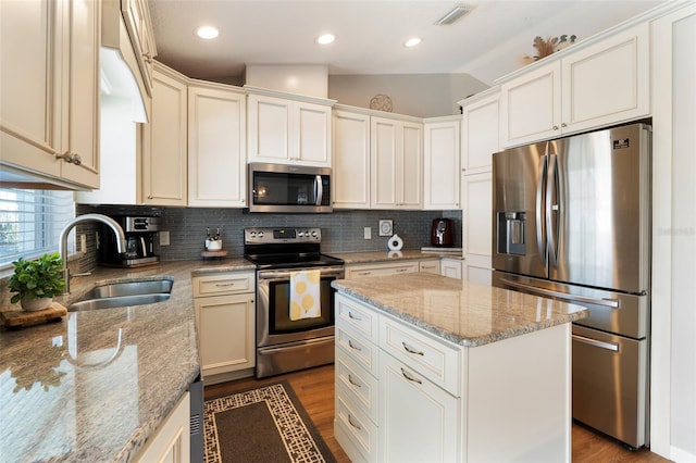 kitchen featuring visible vents, a sink, backsplash, dark wood-style floors, and stainless steel appliances