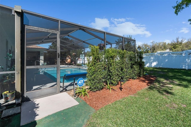 view of swimming pool with glass enclosure, fence, a fenced in pool, a patio area, and a lawn