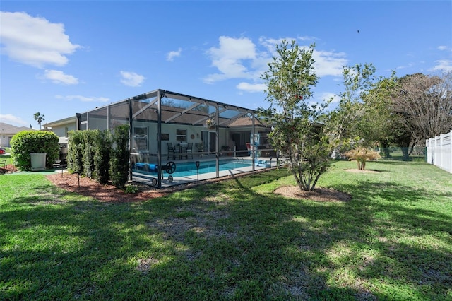 view of yard with glass enclosure, fence, and an outdoor pool