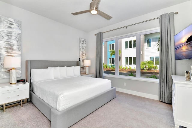 bedroom featuring baseboards, light carpet, and ceiling fan