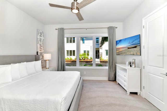 bedroom with light colored carpet, baseboards, and ceiling fan