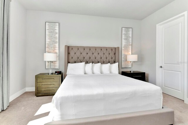 bedroom with light carpet and baseboards