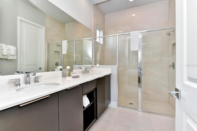 full bath with tile patterned flooring, double vanity, a stall shower, and a sink